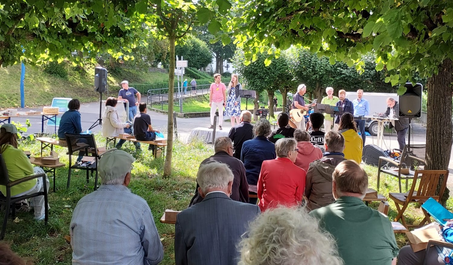 Besucher sitzen auf Bierbänken beim Gottesdienst